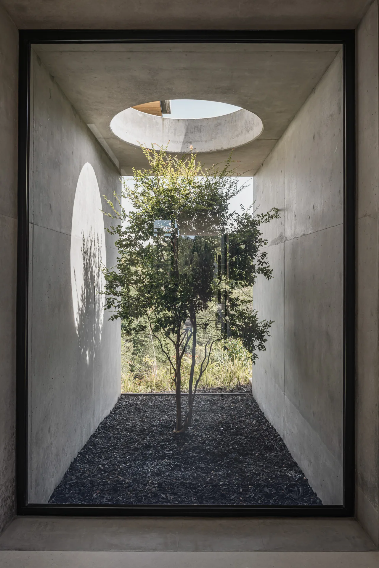 Habitación minimalista con ventanales de piso a techo y acceso directo al jardín.